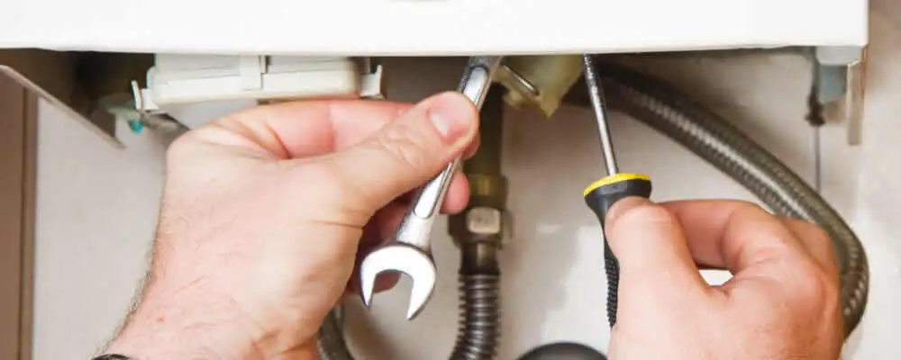 Boiler repair technician tightening pipe fittings and connections in Greensboro, NC