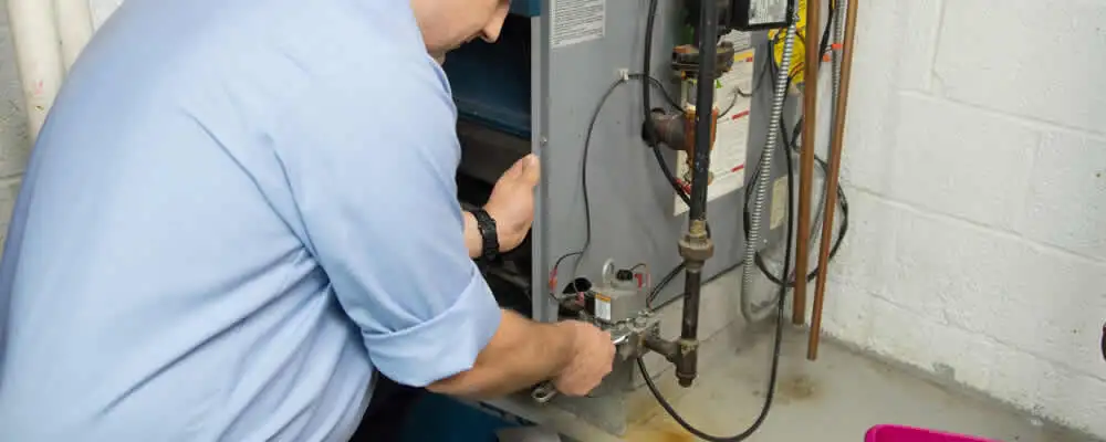 Furnace repair technician inspecting and servicing a home heating system in Greensboro, NC