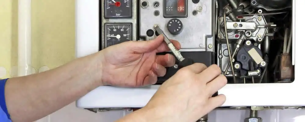 Heating repair technician adjusting boiler controls and components in Greensboro, NC
