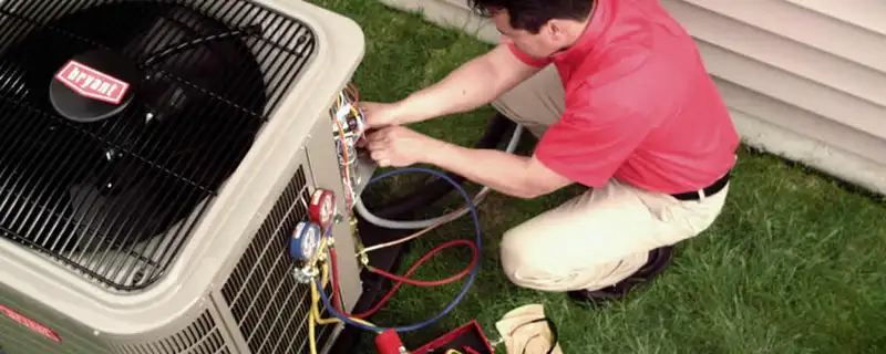 HVAC technician servicing an outdoor air conditioner unit in Greensboro, NC