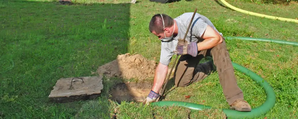 Septic pumping technician servicing a residential septic tank in Greensboro, NC